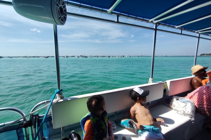 a group of people sitting in a boat on a body of water