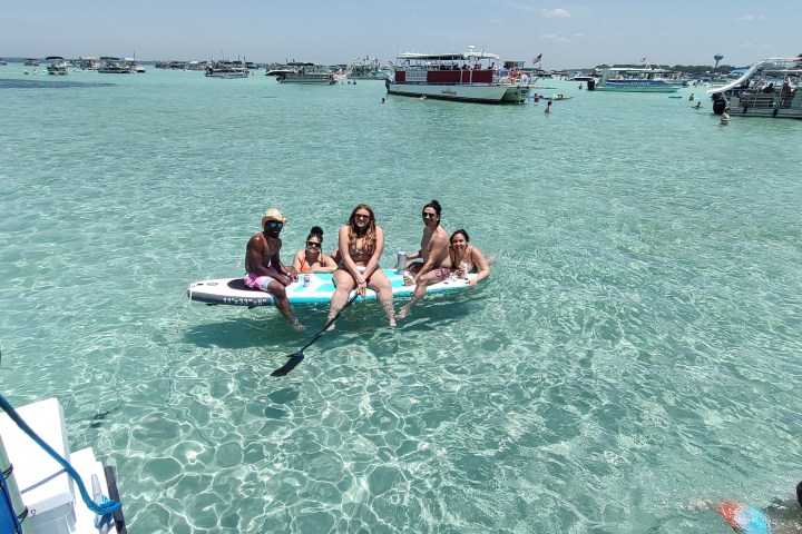 a group of people riding on the back of a boat in the water